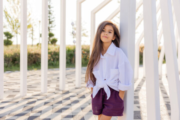 beautiful little girl of Arab appearance with long hair walks in a city park in summer