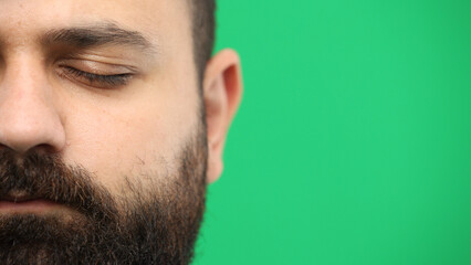 Man's face, close-up, on a green background