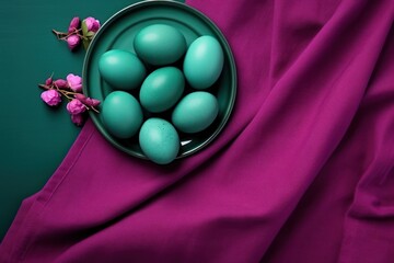  a bowl filled with green eggs sitting on top of a purple cloth next to a pink flower on top of a purple cloth.