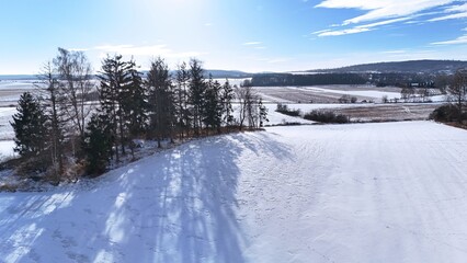  Krajobraz zimowy, śnieg na stoku górskim, drzewa, zdjęcie zrobione pod słońcem.