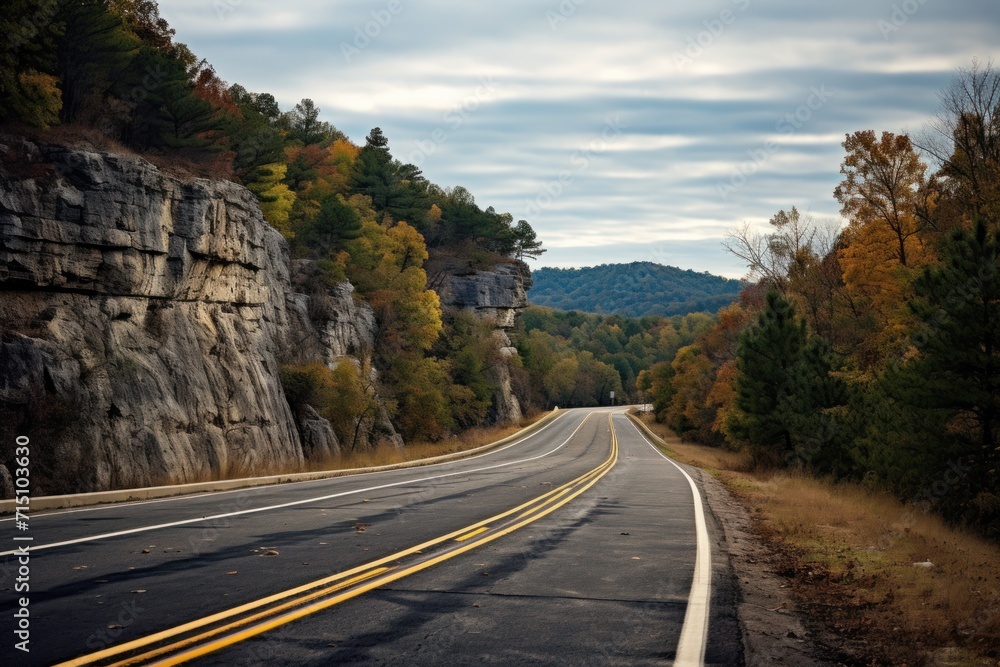 Poster a view of a road with a cliff in the background and trees on both sides of the road and a cliff on t