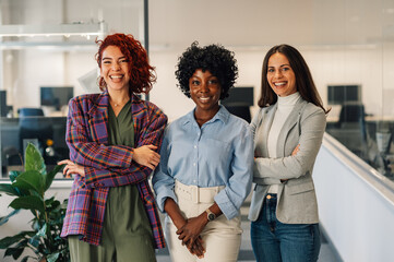 Multiracial women posing in the office while looking into the camera