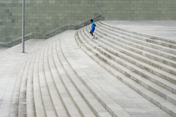 Graceful Descent: Young Man in Blue Sportswear Mastering the Stairs