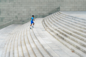Prominent Ascent: Young Man in Blue Sportswear Dominating the Stairs