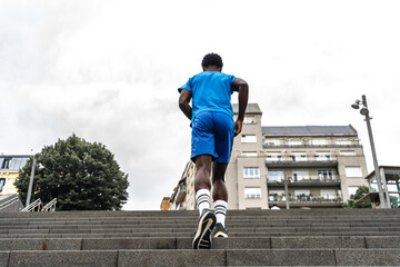 Young black athlete climbing urban stairs