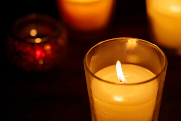 Burning Aromatic Candles in Glass on Dark Background, Close-up