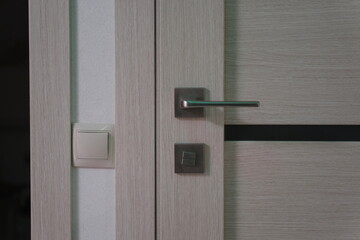Closeup doorknob of wooden door between open or close the door. light switch High quality photo