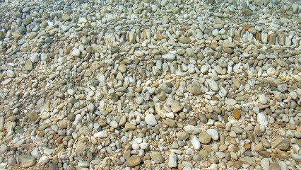Abstract nature background. Backdrop. Wallpaper of little pebbles or stones in sea water. Pebbles under water. Nautical background. Clean sea water. Transparent sea. Beach summer background.