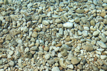 Abstract nature background. Backdrop. Wallpaper of little pebbles or stones in sea water. Pebbles under water. Nautical background. Clean sea water. Transparent sea. Beach summer background.