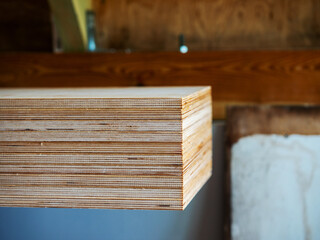 Stack of ply wood and carpenter tools, Roof elements out of focus in the background. Building or repairing house or commercial building. Use of basic cheap material.