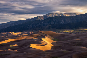 Sunrise in Great Sand Dunes National Park in Colorado with mountains in the background