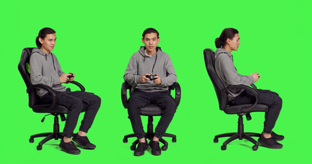 Asian adult enjoying video games over full body greenscreen, using controller and having fun with...