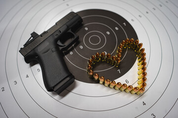 Theme of Valentine's day and weapons. A modern compact pistol with a red dot, a target and a heart...
