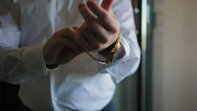 Man wears a gold watch on his arm