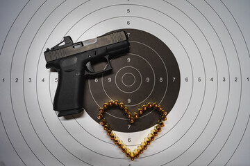 Theme of Valentine's day and weapons. A modern compact pistol g43x with a red dot, a target and a...