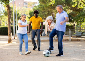 The football team of positive aged and middle-aged diverse people spending time together and having...