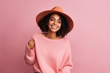 Cheerful african american woman in pink sweater and hat