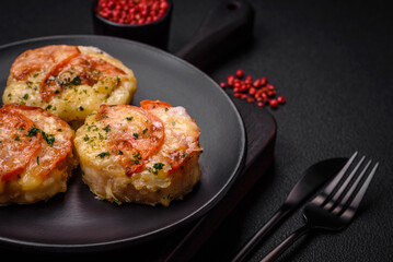 Delicious baked fish fillet with cheese, tomatoes, salt, spices and herbs