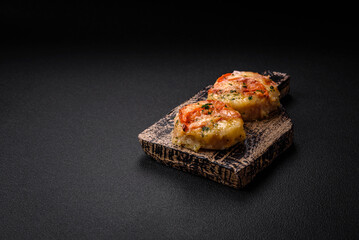 Delicious baked fish fillet with cheese, tomatoes, salt, spices and herbs