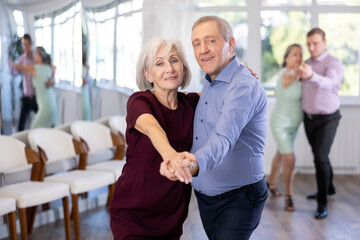 Elderly man and elderly woman dance couple tango dance in studio - obrazy, fototapety, plakaty