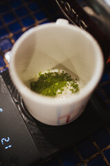 Close up of a barista preparing a green matcha tea. Specialty cafeteria.