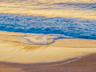 The blue sea during sunrise at the beach with calm seas