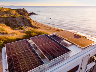 Caravan with solar panels on roof camp on coast, Spain. Aerial view.