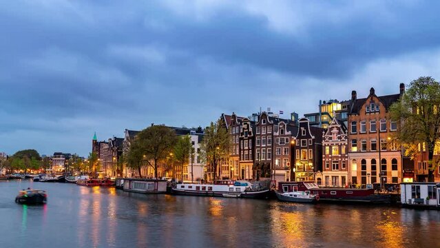 Amsterdam Netherlands, city skyline day to night time lapse at canal waterfront