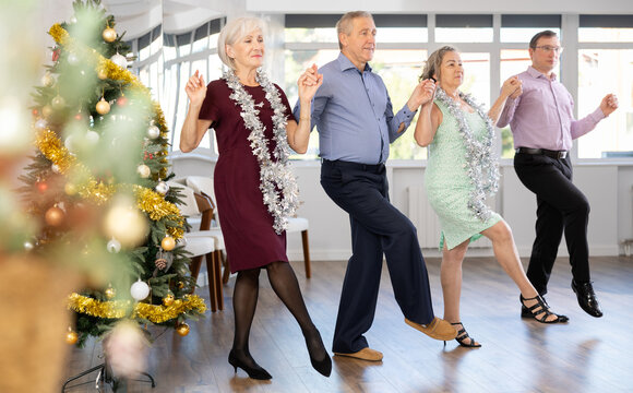 Group of men and women dancing traditional folk dance in studio..