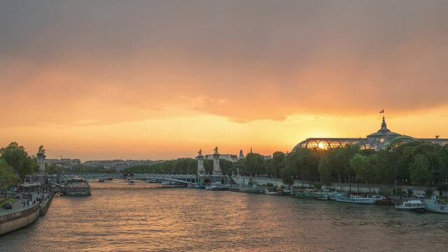 Paris France time lapse, city skyline day to night sunset timelapse at Seine River with Pont Alexandre III bridge and Esplanade des Invalides