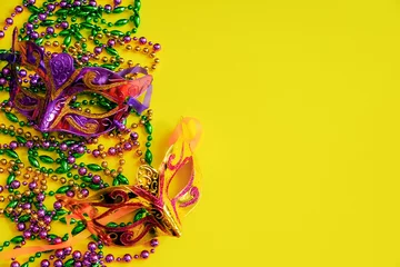 Fototapete Karneval Two multi-colored carnival masks and beads on yellow background. Mardi Gras concept. Fat Tuesday symbol.  © Galina Atroshchenko