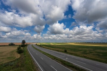 Highway among fields under a beautiful sky with white clouds
