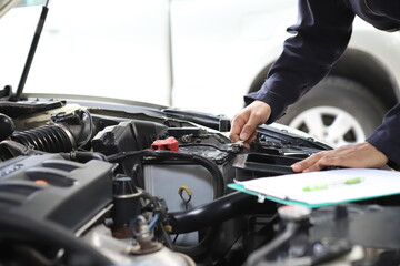 Auto mechanic working in garage. Repair service. Worker mechanics in uniform are working in auto...