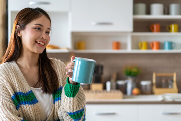 Portrait of smiling happy cheerful beauty pretty asian woman relaxing drinking and looking at cup of hot coffee or tea.Girl felling enjoy having breakfast in holiday morning vacation at home
