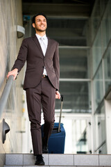 Confident businessman descending stairs with suitcase