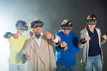 Enthusiastic grandparents with grandchildren in virtual reality glasses in quest room