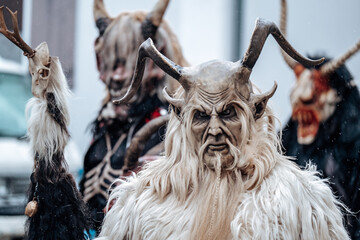 Krampus demon on blurred street background.Winter costume processions on the streets of Europe....