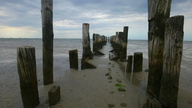 destroyed wooden pillars in the sea on a cloudy day. sea pier.4k footage