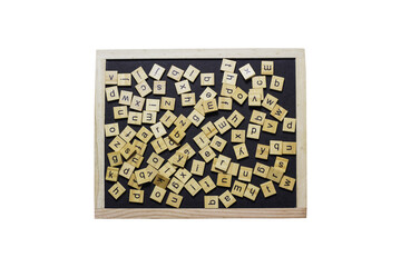 English letters made from square wooden tiles There are English letters scattered on a black background. Concepts for developing grammar thinking