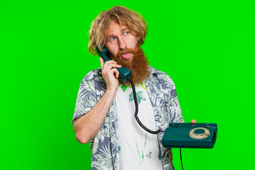 Tired bored man talking on wired vintage telephone of 80s, fooling, making silly faces, exhausted...