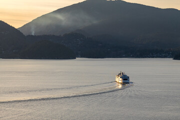 Ferry or boat on Howe Sound at golden hour heading out to sea