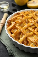 Tasty homemade quince pie and fresh fruits on black wooden table, closeup