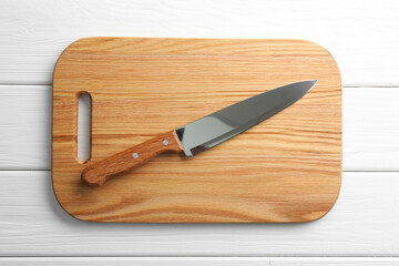 One sharp knife and board on white wooden table, top view