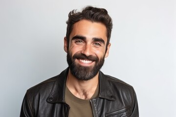 Portrait of a handsome bearded man in leather jacket on grey background