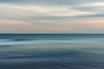 Fototapeta na wymiar Ocean and cloudy sky, abstract seascape background, motion blur.