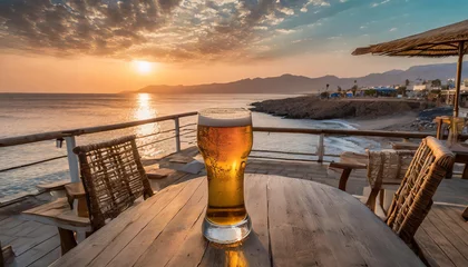 Rucksack Sipping a fresh beer waiting to admire the fantastic sunset on the beach cafe © Callow