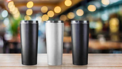 Obraz premium Closeup of 3 tumbler product mock up on light color on wooden floor with blur and bokeh cafe background