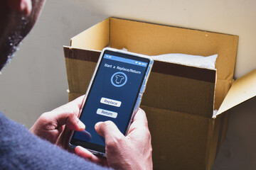 A South Asian man starting the process to return a product purchased online. Mockup, selective focus on the smartphone screen.