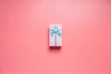 Top view photo of valentine's day decorations giftbox with silk ribbon bow on isolated pastel pink background with copyspace, concept Valentine's Day.