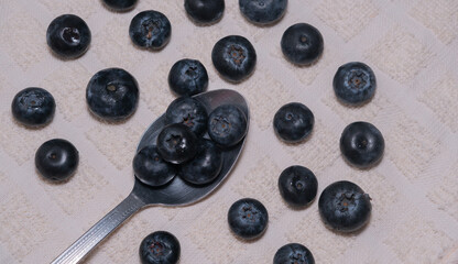 High angle view of fresh blueberries and spoon on table